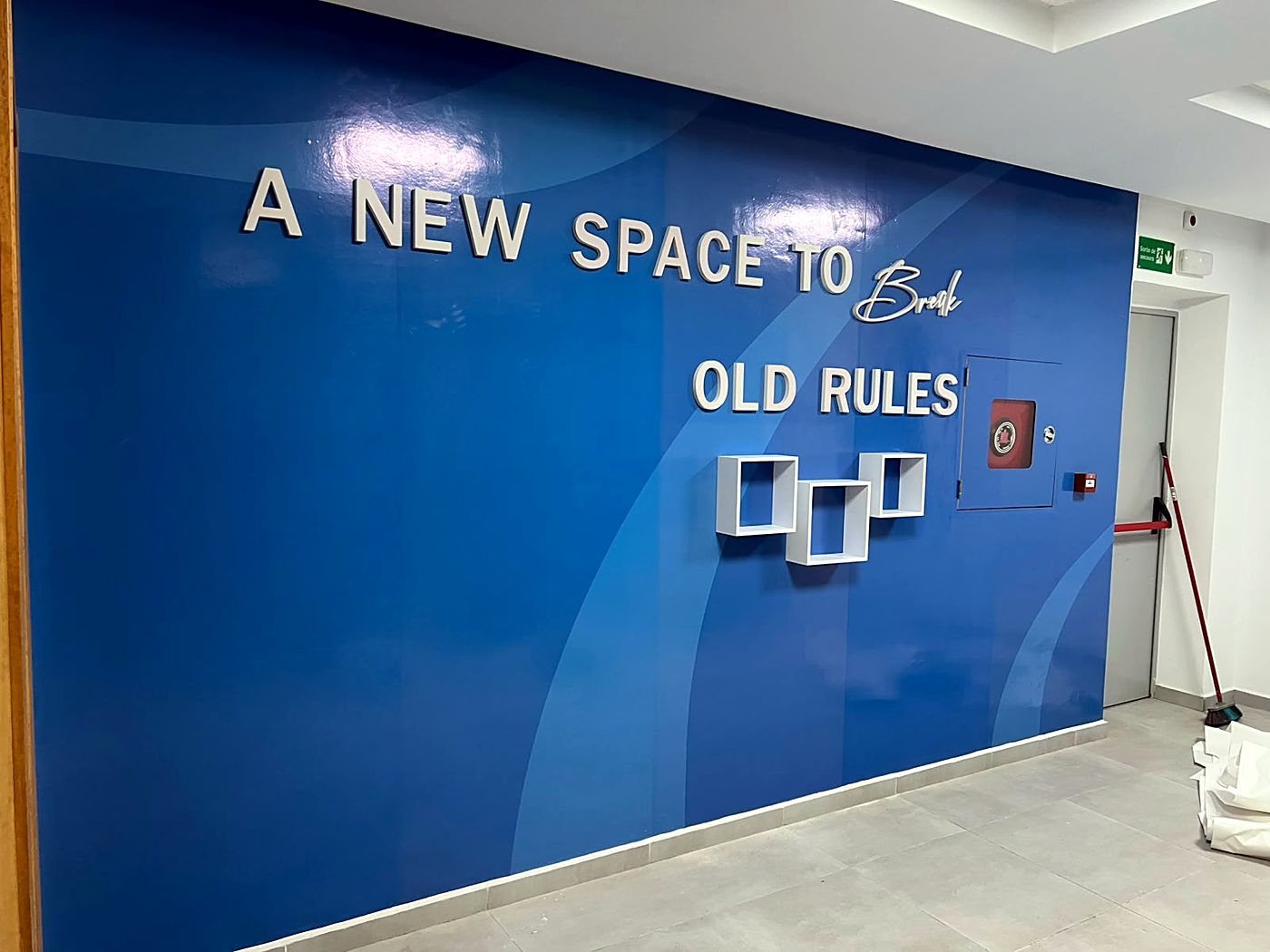 Mur bleu imprimé avec lettres en relief A new space to break old rules